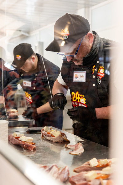 Butchers preparing the steaks through the glass screen
