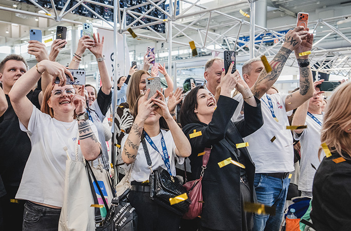 people cheer while holding a camera to take pictures
