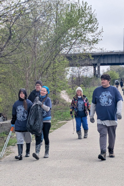 A family at the event walking with a bag of trash