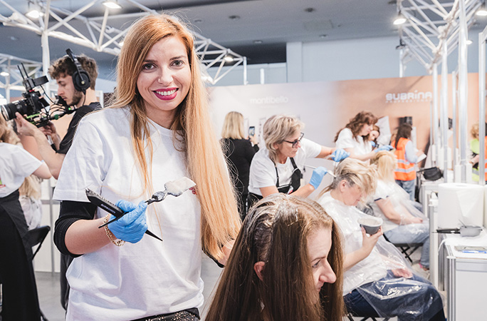 woman smiles holding up white hair brush