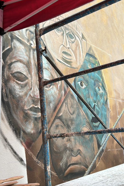 Closeup of some of the faces being painted on the mural
