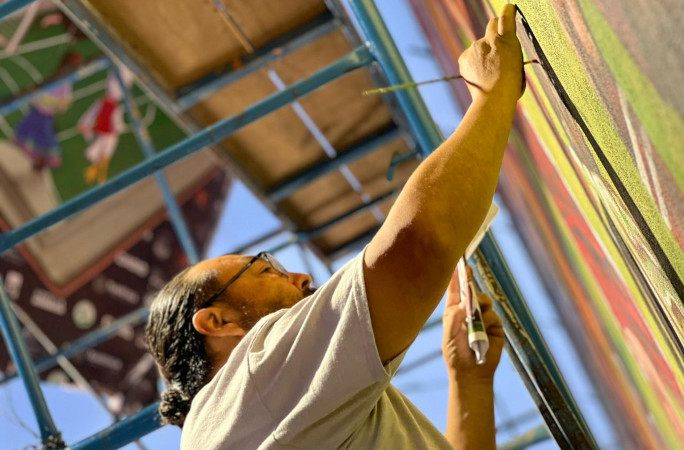 Closeup of a worker painting on the mural