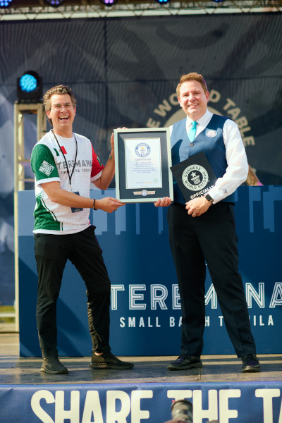 Michael holding a certificate with an event organizer