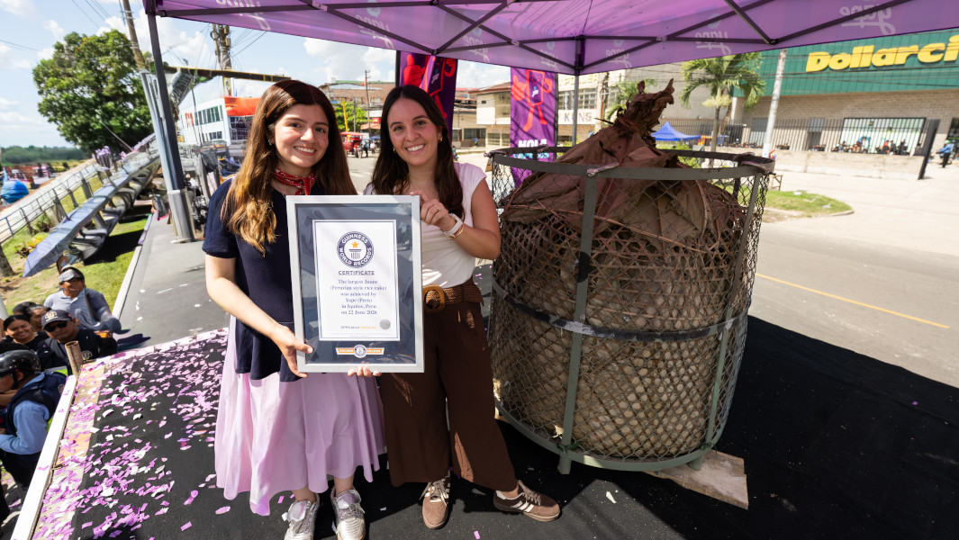 Two women standing next to the giant Juane and holding a GWR certificate