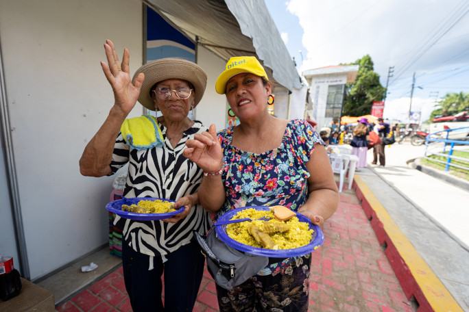 Two women eating plates of Juane