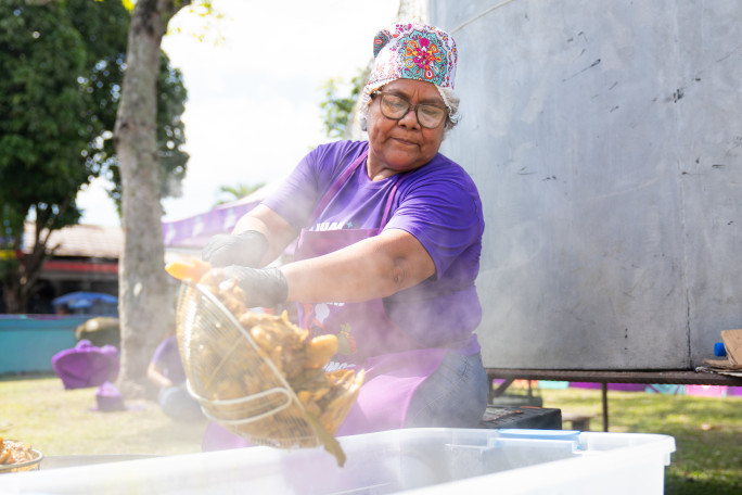 A woman dumping chicken into the pot