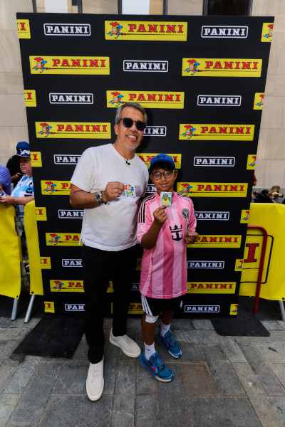 Pavel and a child posing with their Panini stickers