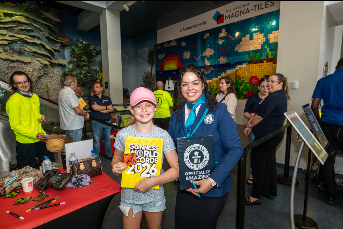 Adjudicator and a kid with a GWR book in front of the mural