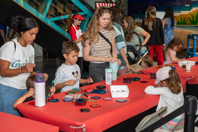 Families playing with the MAGNA TILES in front of the mosaic