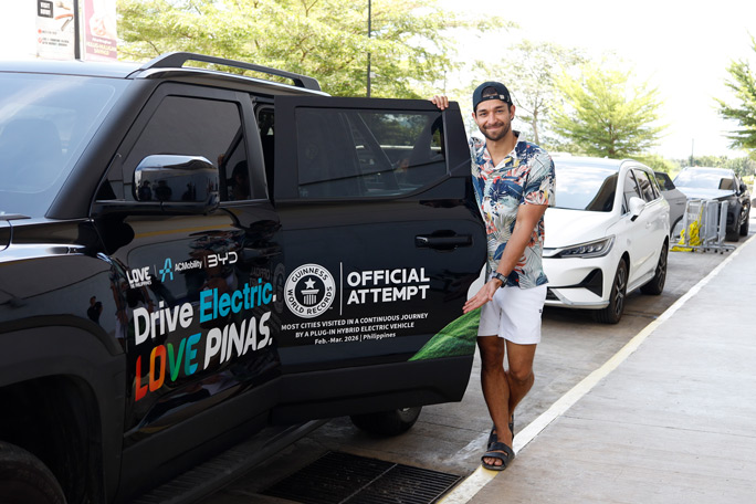 A person in front of BYD Shark 6 DMO - most cities visited in a continous journey