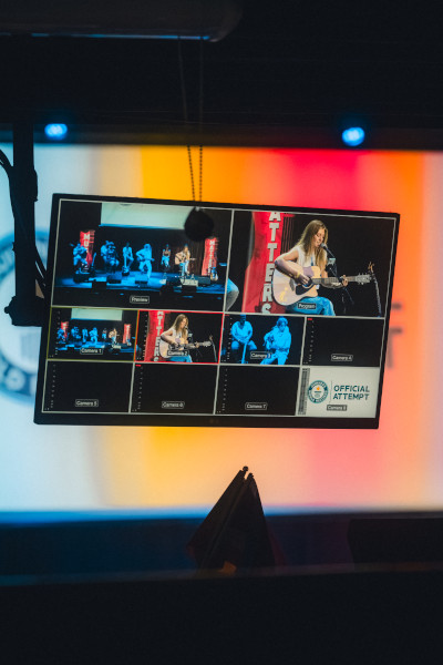 Shot of a backstage screen showing multiple artists performing at once