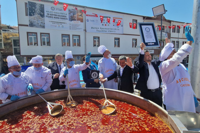 Chefs celebrating next to the beans and holding their certificate