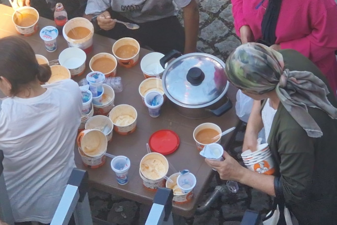 Overhead shot of a table of people eating the baked beans