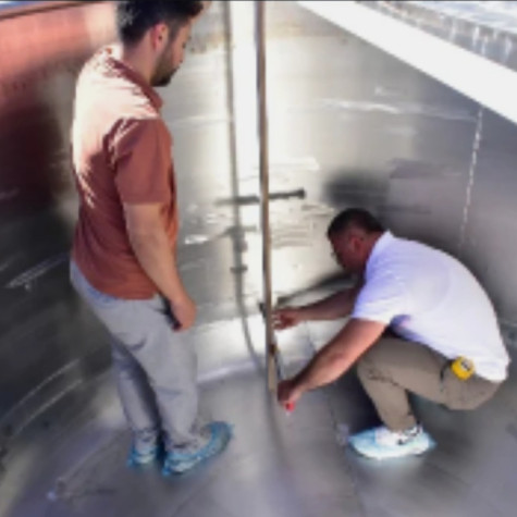 Men standing in the pot and measuring it