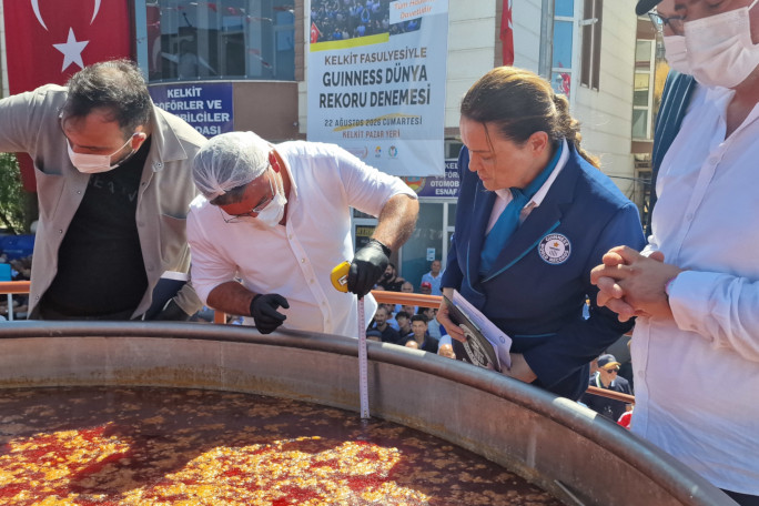 Adjudicator witnessing the men measuring the amount of beans in the pot