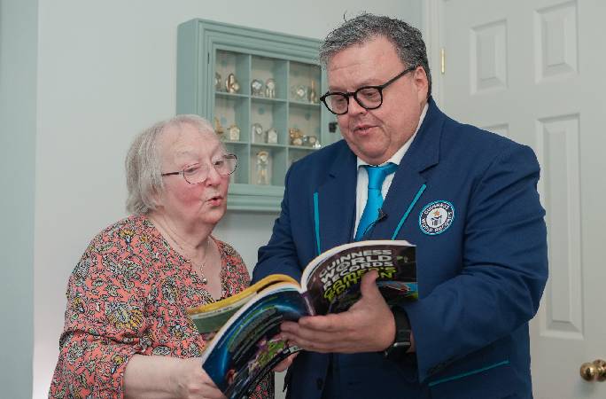 Editor in Chief Craig Glenday shows oldest female Fortnite streamer Cath Bowie her page in the Gamer's Edition 2027. 