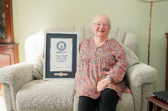 Cath Bowie, the oldest Fortnite streamer on Twitch, checking out her page in the Guinness World Record Gamer's Edition 2027, with Editor in Chief Craig Glenday