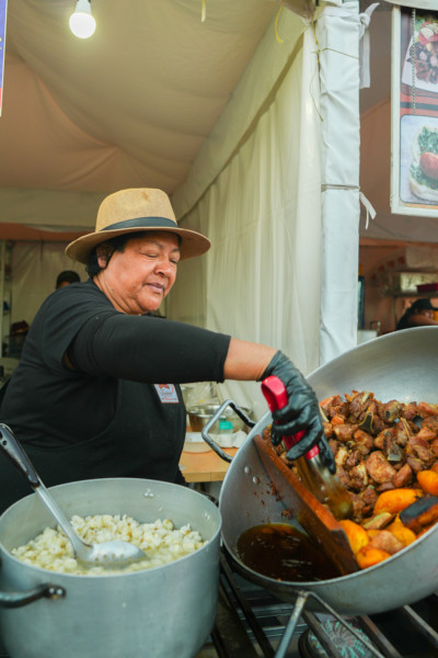 Woman dishing out meat next to rice