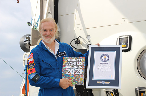Victor Vescovo on boat holding Guinness World Records book