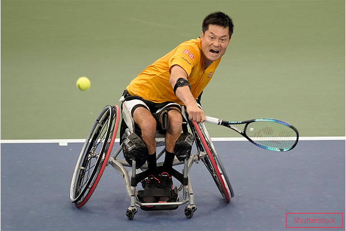Shingo Kunieda hitting a tennis ball with his racket