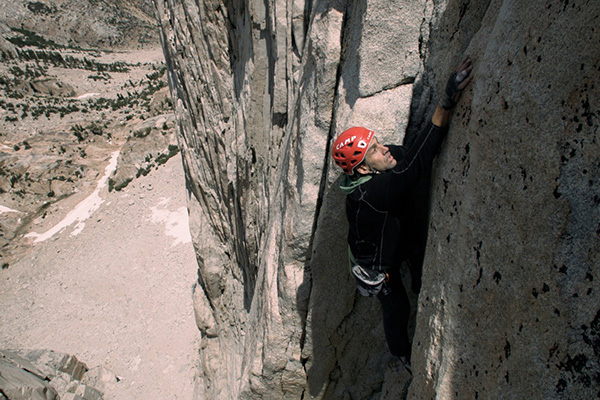 Erik climbing wearing a red helmet
