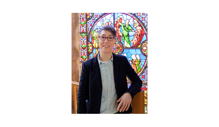 Jasmine Allen standing in front of a stained glass window