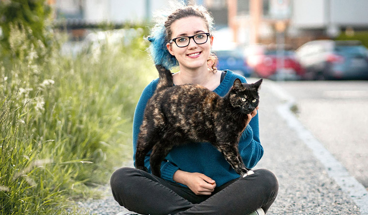 Alexis the cat sitting on the lap of his owner Anika Moritz 