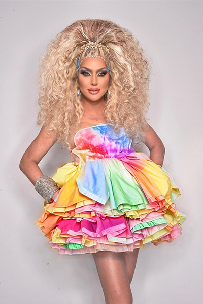 Kay Long posing in a rainbow inspired mini dress